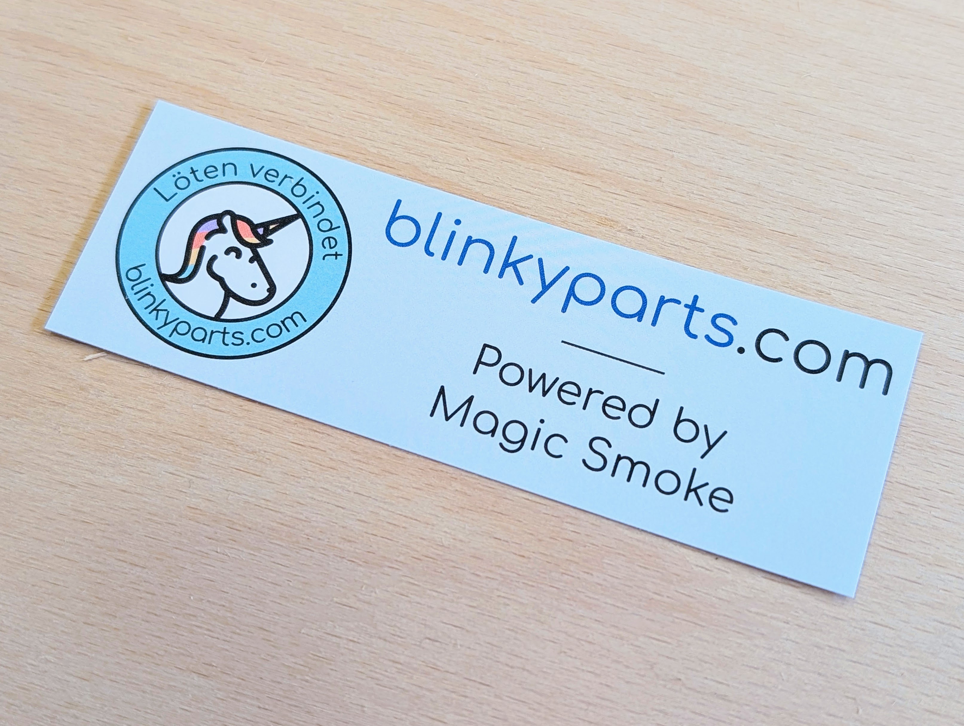 Blinkyparts logo sticker in angled view, showing 3D perspective of company logo with web address and ‘Powered by magic smoke’ slogan