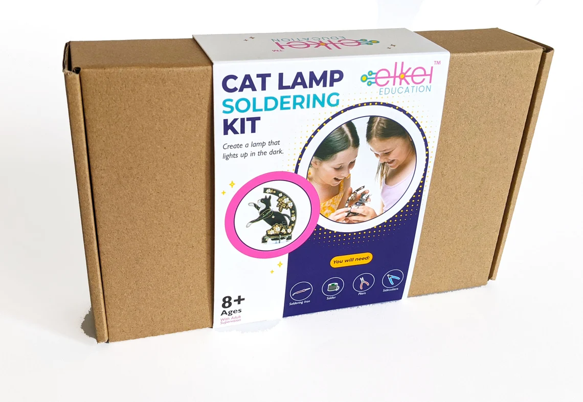 Cat Lamp Soldering Kit Verpackung eines Lötbausatzes „Cat Lamp“ mit Produktfoto, Kindern beim Löten und Werkzeug-Icons; ab 8 Jahren geeignet.