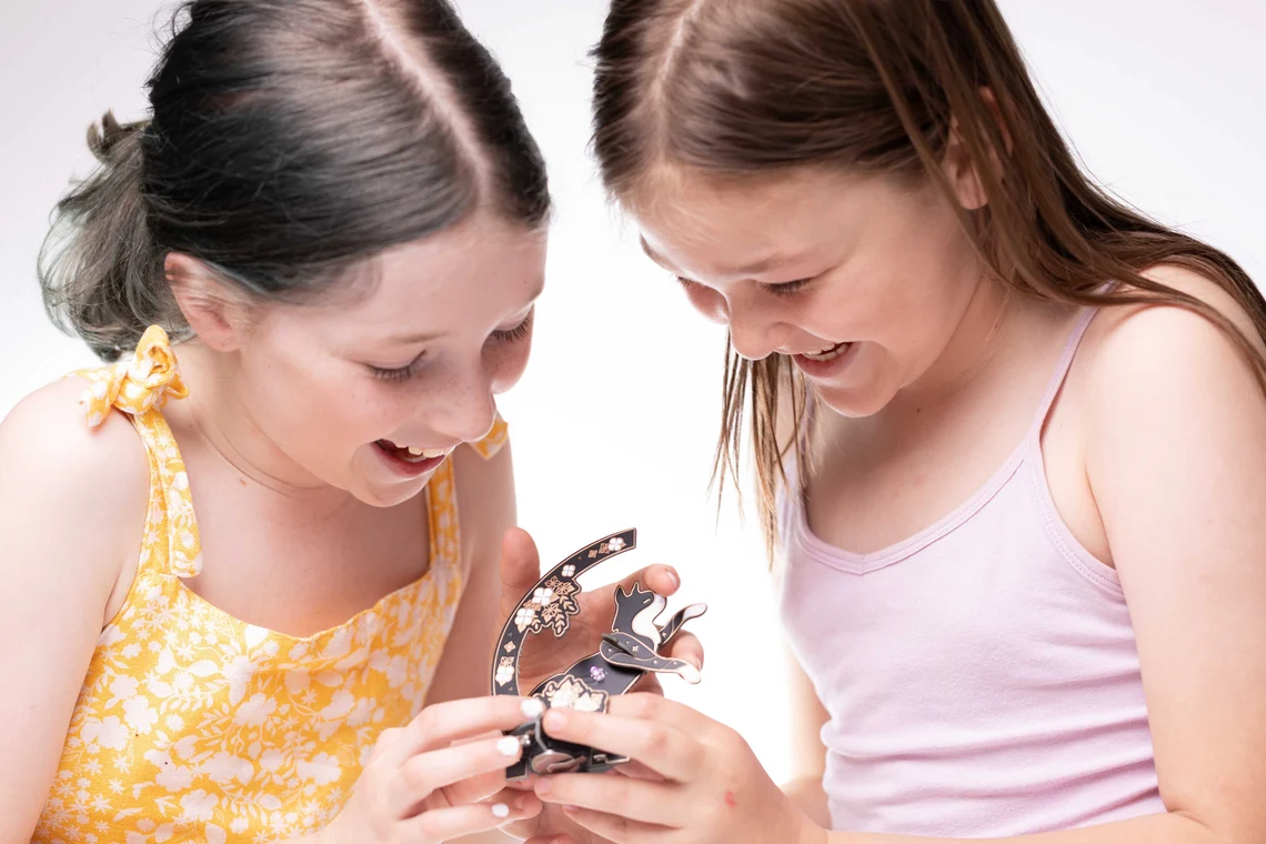 Cat Lamp Soldering Kit Lötbausatz aus schwarzer Platine in Katzenform mit LEDs, Sternmotiven und floralen PCB-Elementen im Hintergrund.