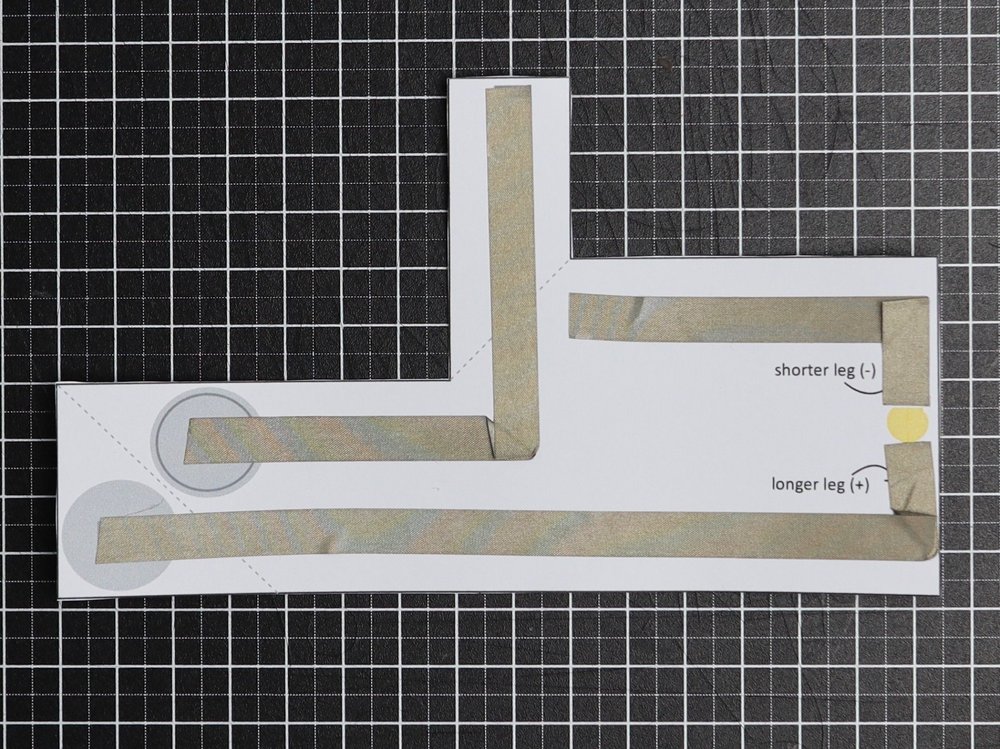 Aufgefaltete Schaltung zum Nachbauen mit leitfähigem Klebeband und elektronischen Komponenten