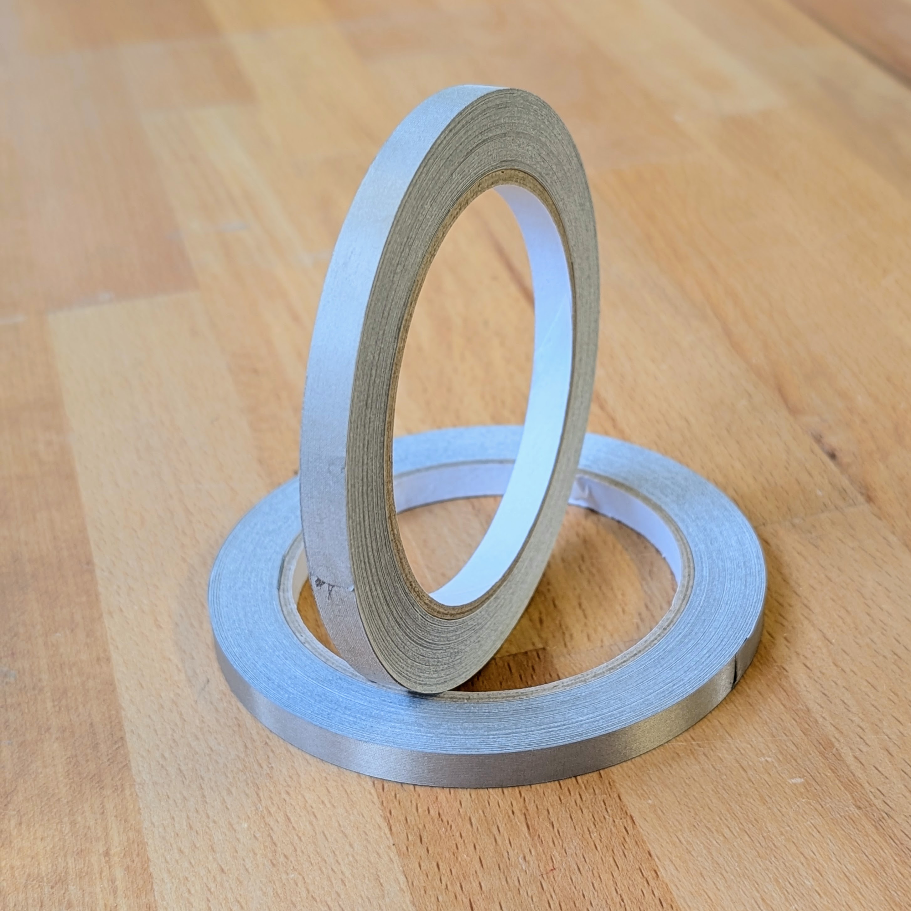 Two rolls of conductive tape, one standing upright for better presentation